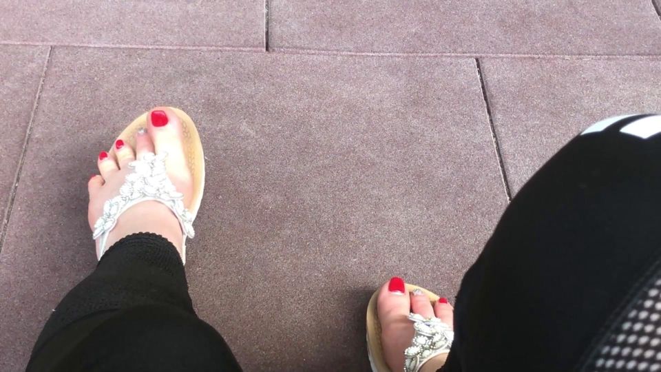 Sandals teasing outdoor with red toenails & toes wiggling